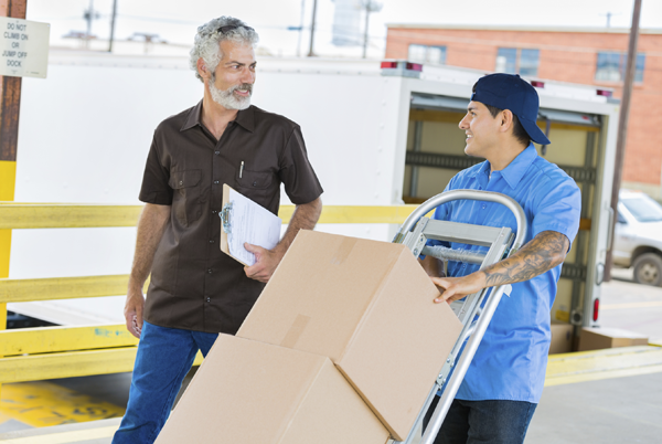 Two men transporting boxes on a loading dock